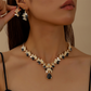 Set med halsband och örhängen med glittrande droppformade hängsmycken